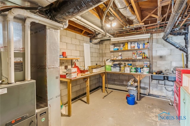 unfinished below grade area featuring concrete block wall, a workshop area, and heating unit