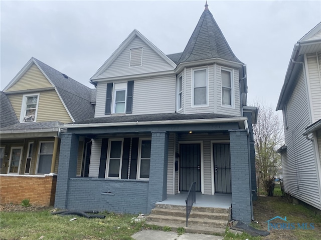 734 Parker Ave, Toledo, OH 43605 - victorian house with brick siding, covered porch, and roof with shingles