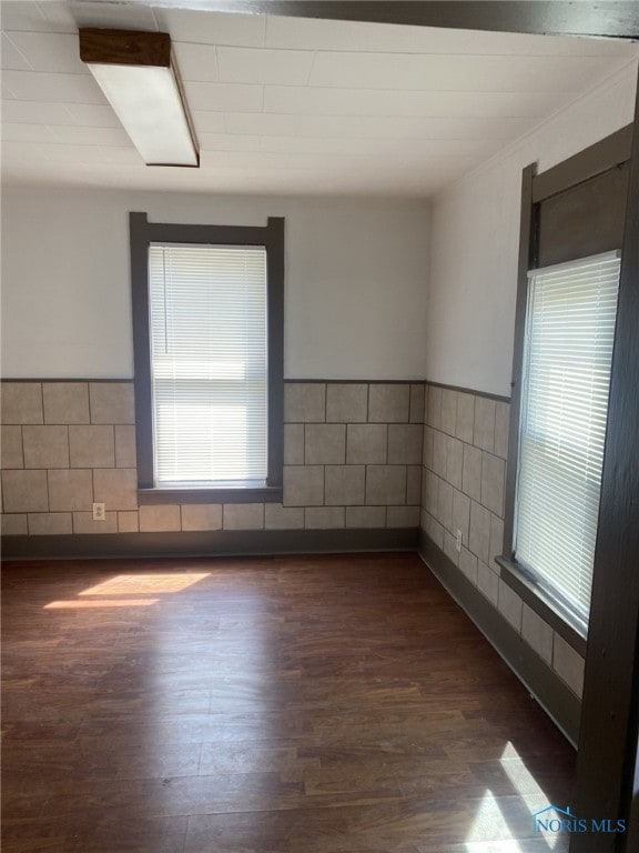 734 Parker Ave, Toledo, OH 43605 - spare room with wainscoting, a healthy amount of sunlight, wood finished floors, and tile walls