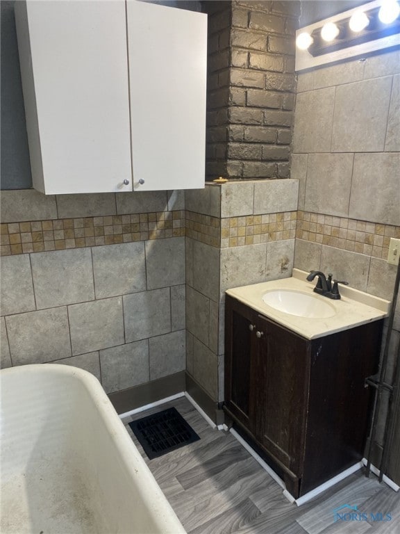 734 Parker Ave, Toledo, OH 43605 - bathroom with a freestanding bath, tile walls, vanity, and wood finished floors