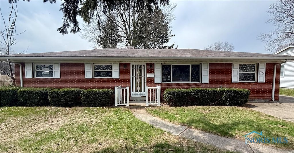 view of front of house with a front yard and brick siding