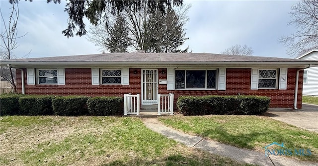 view of front of house with a front yard and brick siding