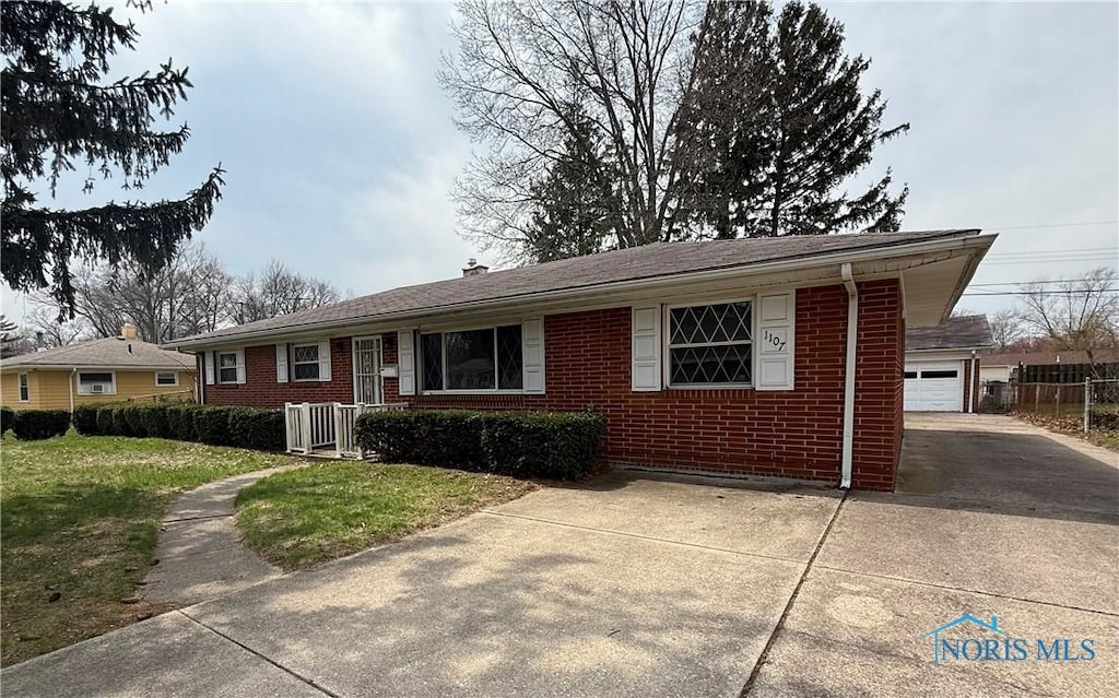 ranch-style home featuring brick siding, a front lawn, a garage, and driveway
