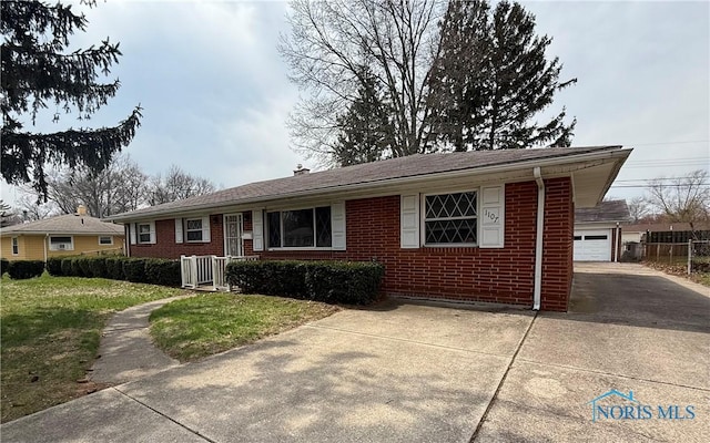 ranch-style home featuring brick siding, a front lawn, a garage, and driveway