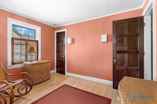 sitting room featuring light wood-style floors, baseboards, and crown molding
