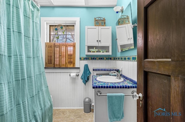 bathroom featuring a wainscoted wall and vanity