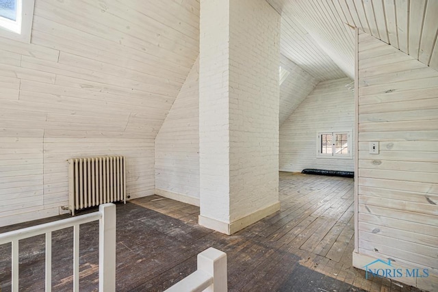 bonus room featuring wooden walls, radiator heating unit, vaulted ceiling, and dark wood-style floors