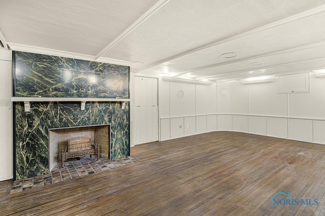 basement featuring a high end fireplace and wood finished floors