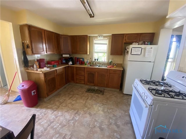702 Clark St, Toledo, OH 43605 - kitchen featuring a sink, light countertops, white appliances, brown cabinets, and backsplash