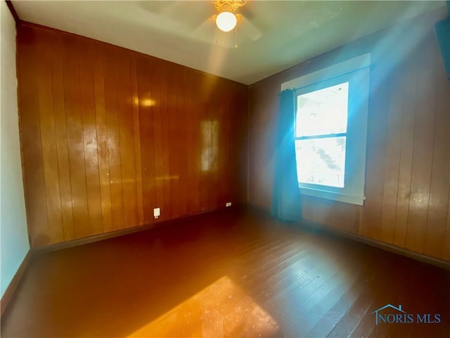 715 Raymer Blvd, Toledo, OH 43605 - empty room featuring wooden walls, a ceiling fan, and hardwood / wood-style flooring