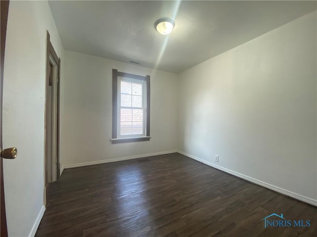 715 Raymer Blvd, Toledo, OH 43605 - spare room featuring baseboards and dark wood-style floors
