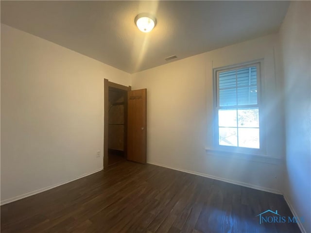 715 Raymer Blvd, Toledo, OH 43605 - unfurnished room with dark wood-style flooring, visible vents, and baseboards