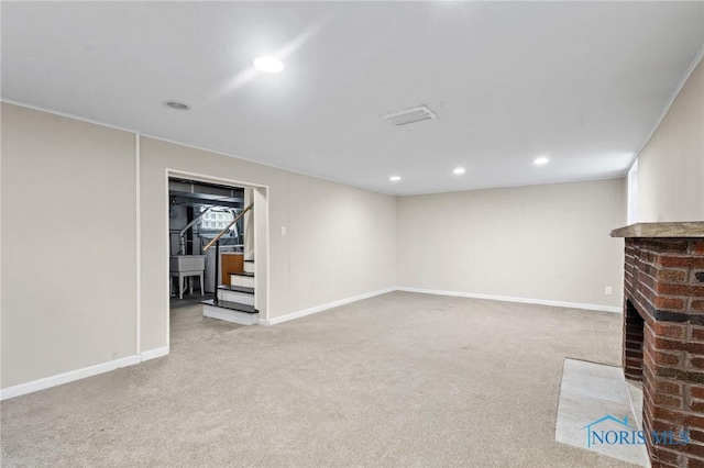 finished basement with recessed lighting, carpet flooring, a brick fireplace, and stairs