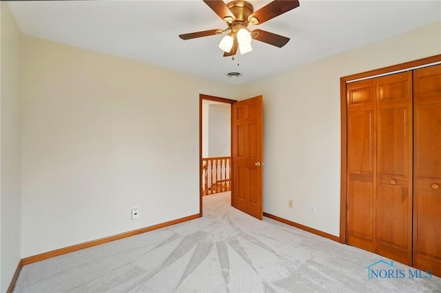 unfurnished bedroom featuring a closet, light colored carpet, baseboards, and visible vents