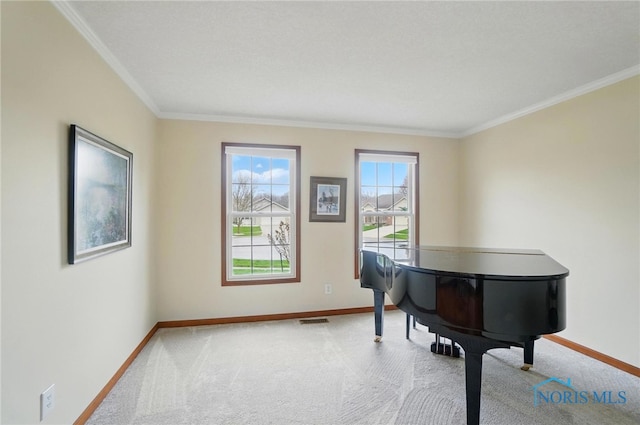 sitting room with visible vents, baseboards, and ornamental molding