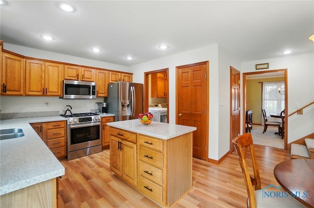 kitchen featuring light wood-style floors, independent washer and dryer, recessed lighting, a kitchen island, and appliances with stainless steel finishes