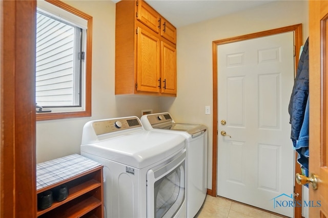 laundry room with light tile patterned flooring, cabinet space, and washing machine and dryer