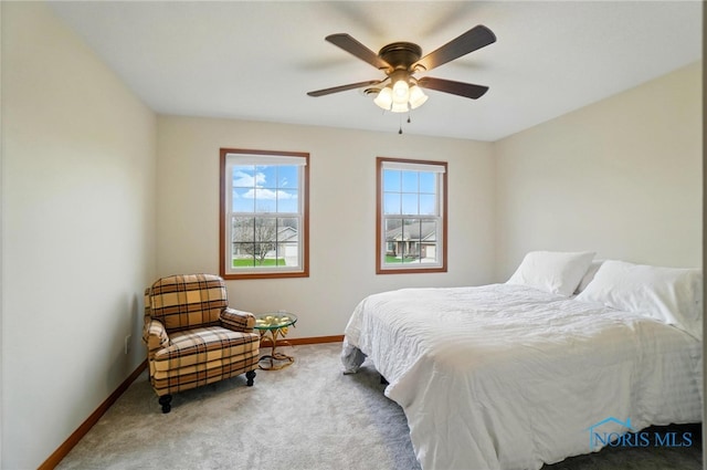 carpeted bedroom featuring baseboards and ceiling fan