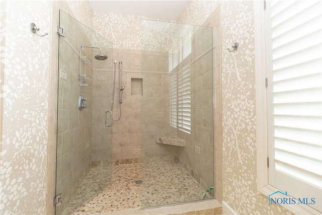 full bathroom featuring wallpapered walls and a stall shower