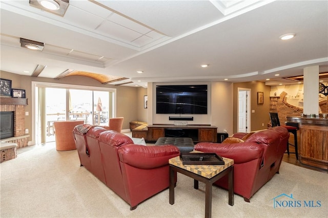 living area with recessed lighting, a brick fireplace, and light carpet