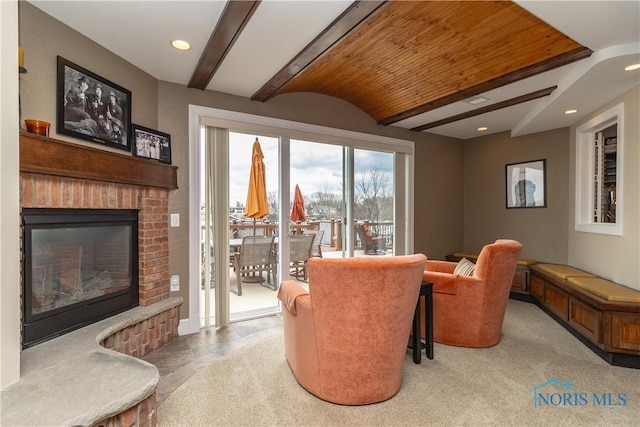 sitting room with vaulted ceiling with beams, a fireplace, and recessed lighting