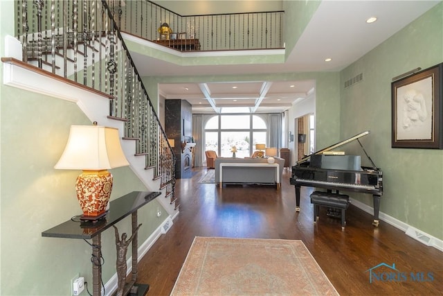 foyer featuring visible vents, recessed lighting, coffered ceiling, wood finished floors, and stairs
