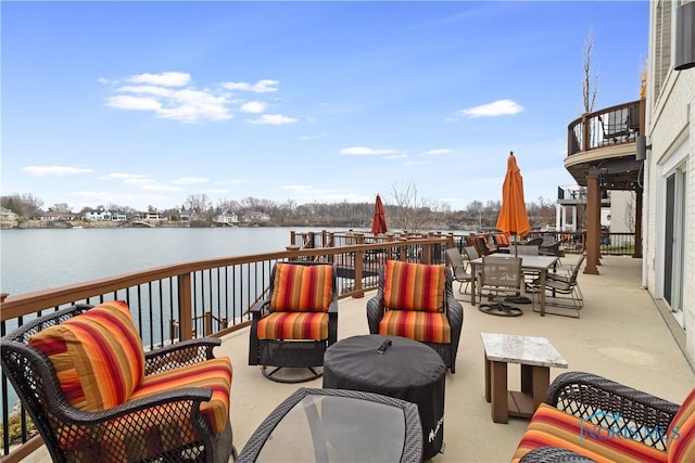 view of patio / terrace featuring outdoor lounge area, a balcony, outdoor dining space, and a water view
