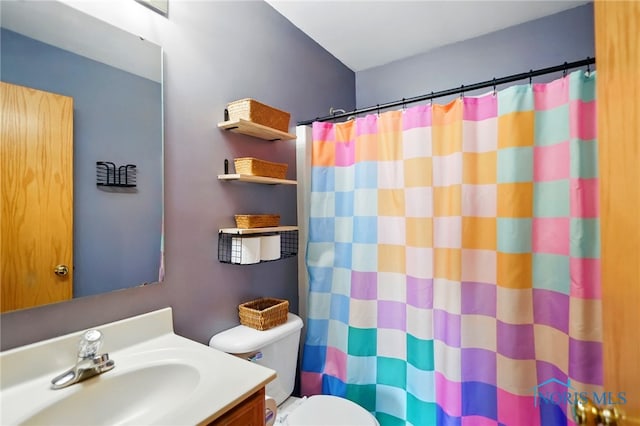 full bathroom featuring vanity, a shower with shower curtain, and toilet