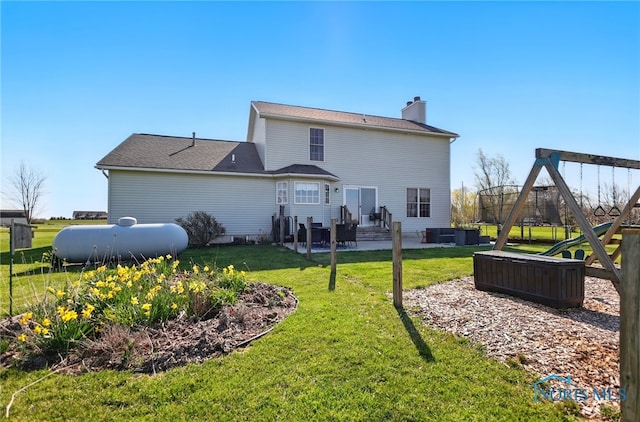 rear view of property featuring a patio area, a playground, a chimney, outdoor lounge area, and a yard