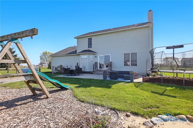 back of house with a yard, a trampoline, a patio area, and a playground