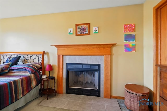 bedroom featuring a tile fireplace and tile patterned floors