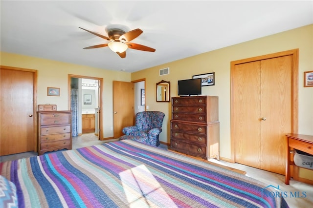 bedroom with ensuite bath, baseboards, a ceiling fan, and visible vents