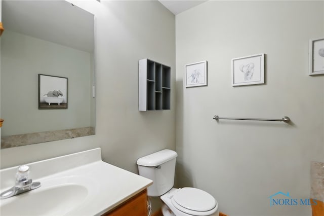 half bath featuring toilet and vanity