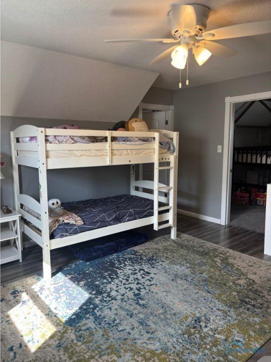 bedroom featuring wood finished floors, baseboards, and a ceiling fan