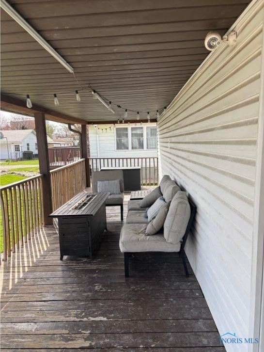 wooden terrace with an outdoor living space