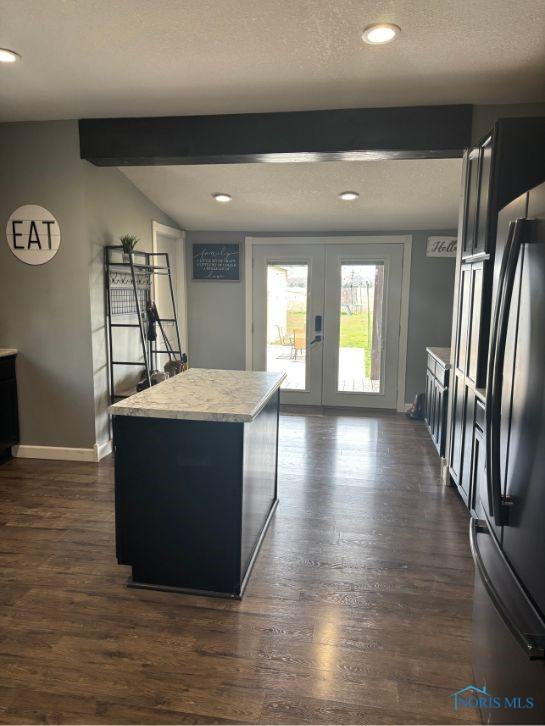 kitchen featuring baseboards, french doors, a textured ceiling, freestanding refrigerator, and dark wood-style floors