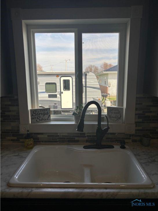 interior details with tasteful backsplash, light stone counters, and a sink