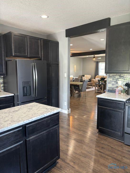 kitchen with stainless steel fridge with ice dispenser, dark wood-style flooring, a textured ceiling, and ceiling fan