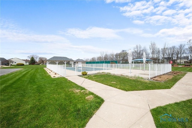 view of property's community with fence, a pool, a gazebo, and a yard