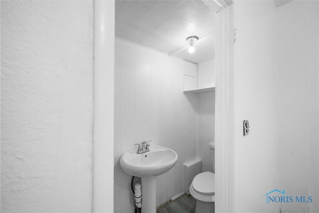 3251 Cottage Ave, Toledo, OH 43608 - half bath with toilet, wood finished floors, a textured ceiling, and a sink