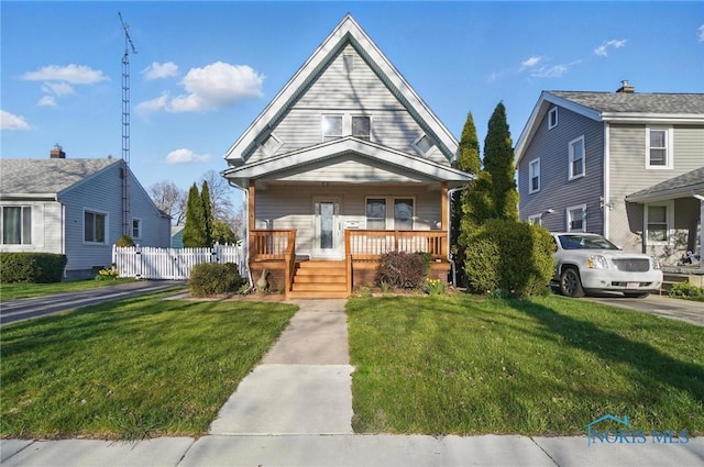 view of front of property with a porch, a front lawn, and fence