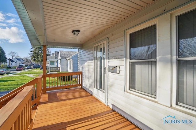 wooden deck featuring a residential view and covered porch