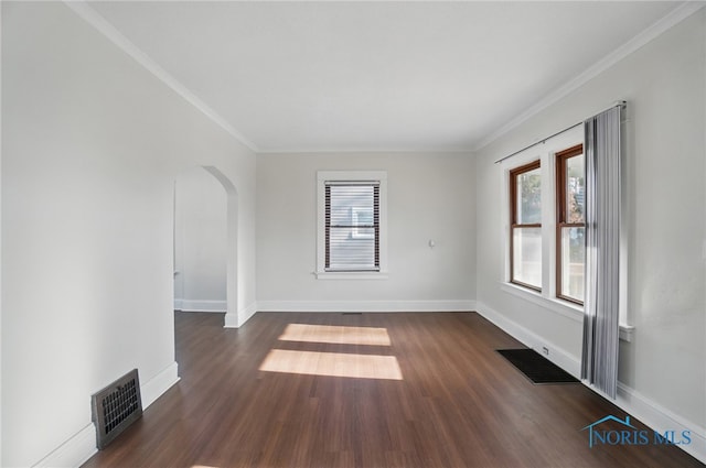 spare room featuring visible vents, dark wood-type flooring, and ornamental molding