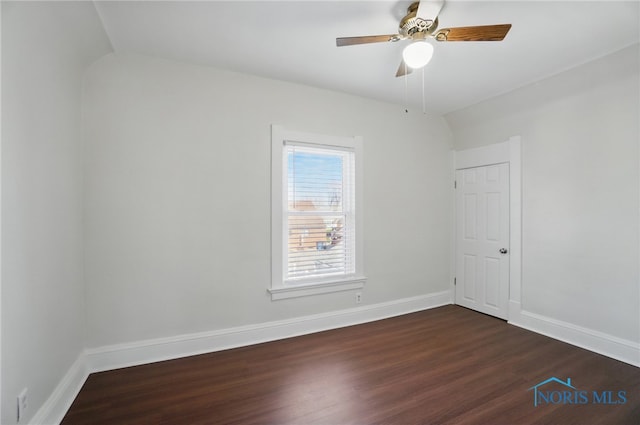 empty room with ceiling fan, baseboards, and dark wood-style flooring