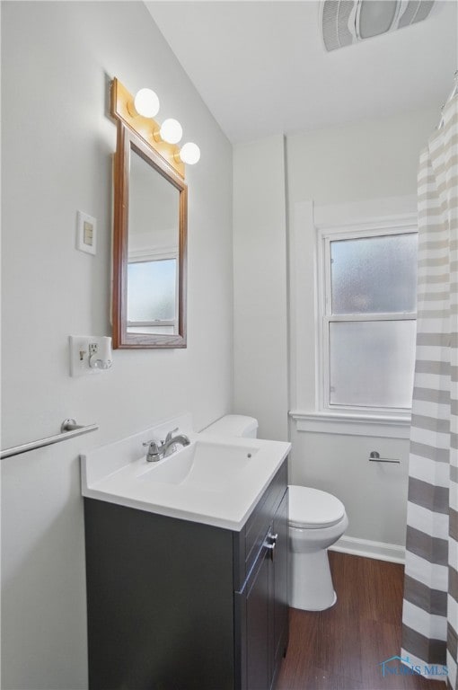 bathroom featuring wood finished floors, visible vents, toilet, and vanity