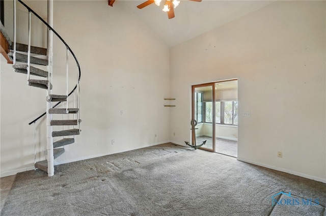 unfurnished living room featuring ceiling fan, high vaulted ceiling, carpet flooring, and stairway