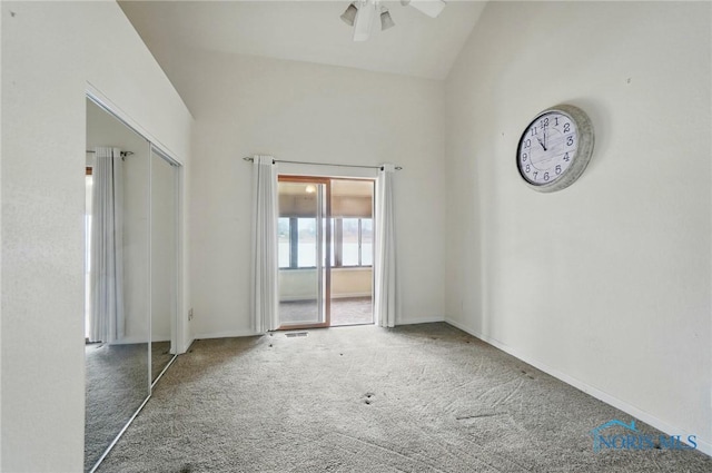 unfurnished bedroom featuring a closet, baseboards, carpet, and lofted ceiling