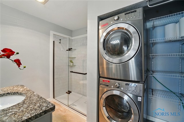 washroom with stacked washing maching and dryer, laundry area, and a sink