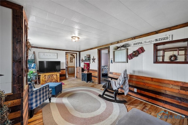 living area featuring wood-type flooring and wood walls