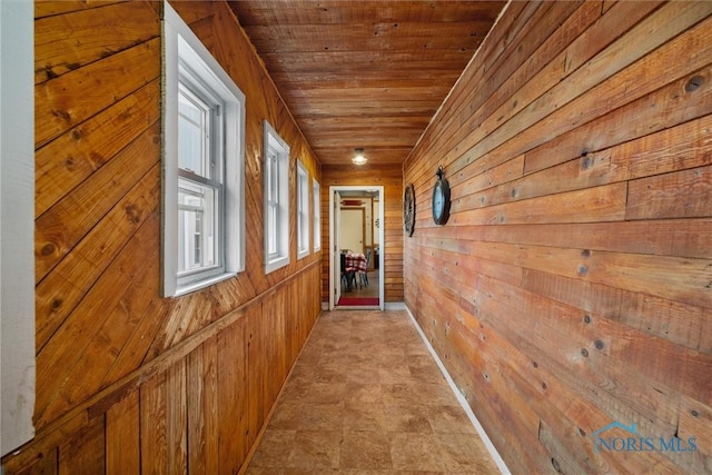 hall with wood ceiling and wooden walls